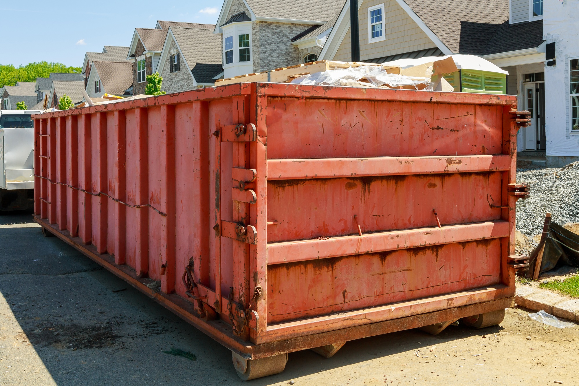 Residential view of new houses being built and construction garbage large container