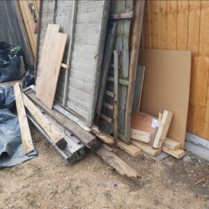 Before: old fence panels and timber waste in a garden